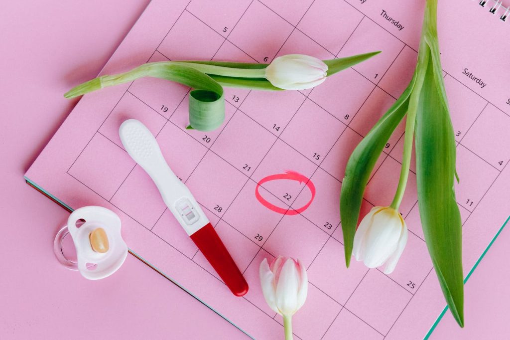 pexels-photo-5982466 Pregnancy test on pink calendar with tulips, symbolizing fertility and new beginnings.